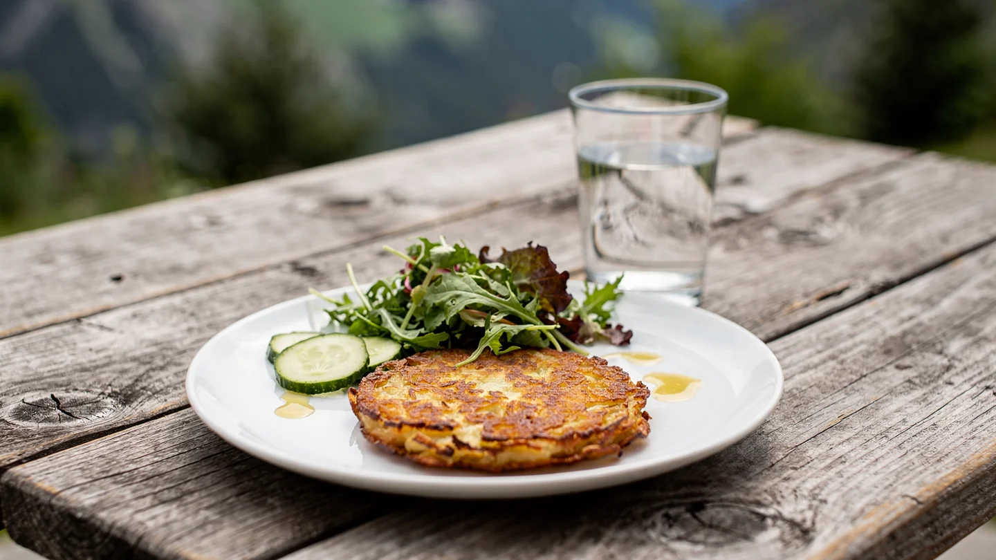An illustrative outdoor meal of rösti and salad